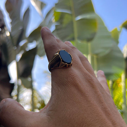 Dorado con piedra negra y detalles a los costados