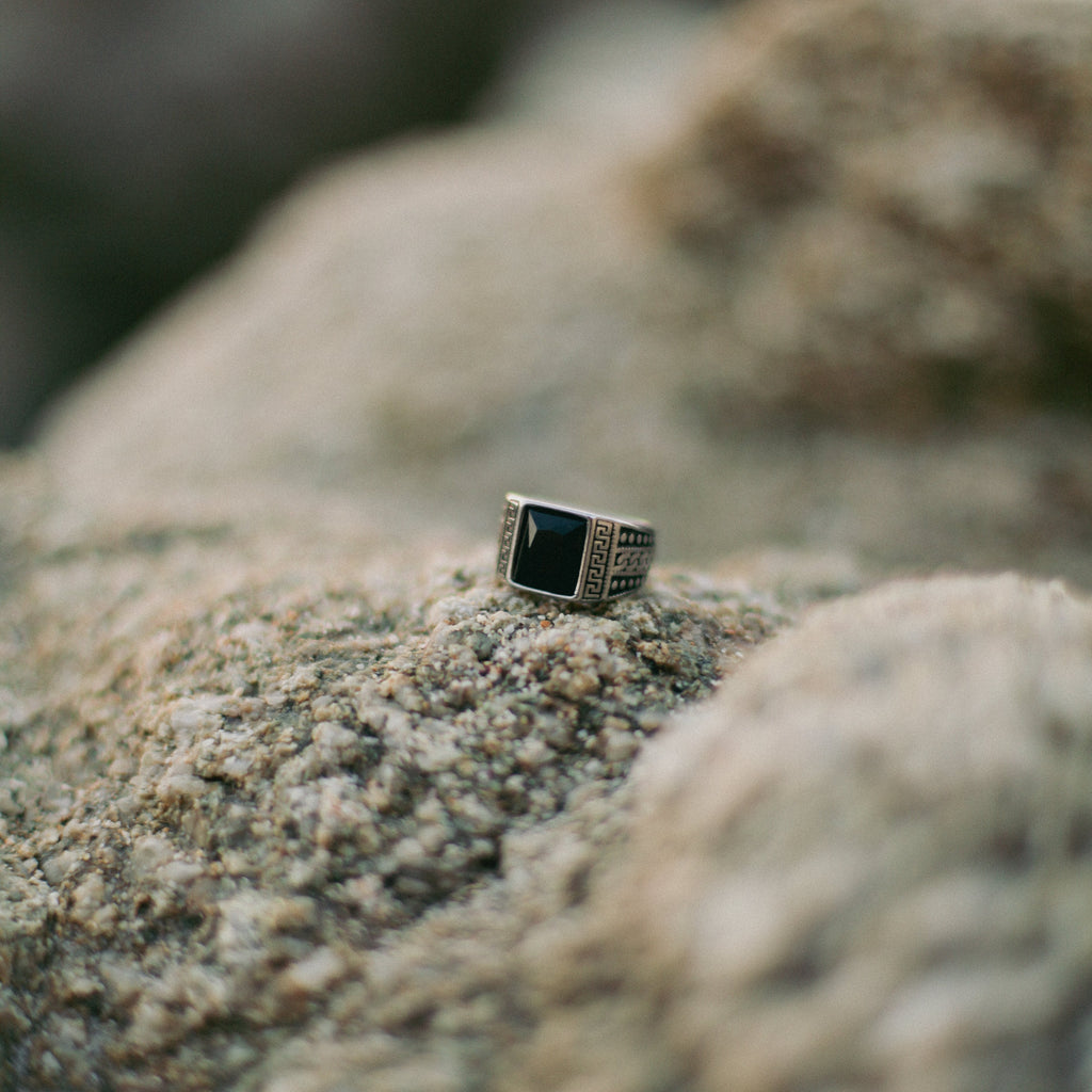 Anillo con piedra cuadrada y grecas con puntos a los laterales