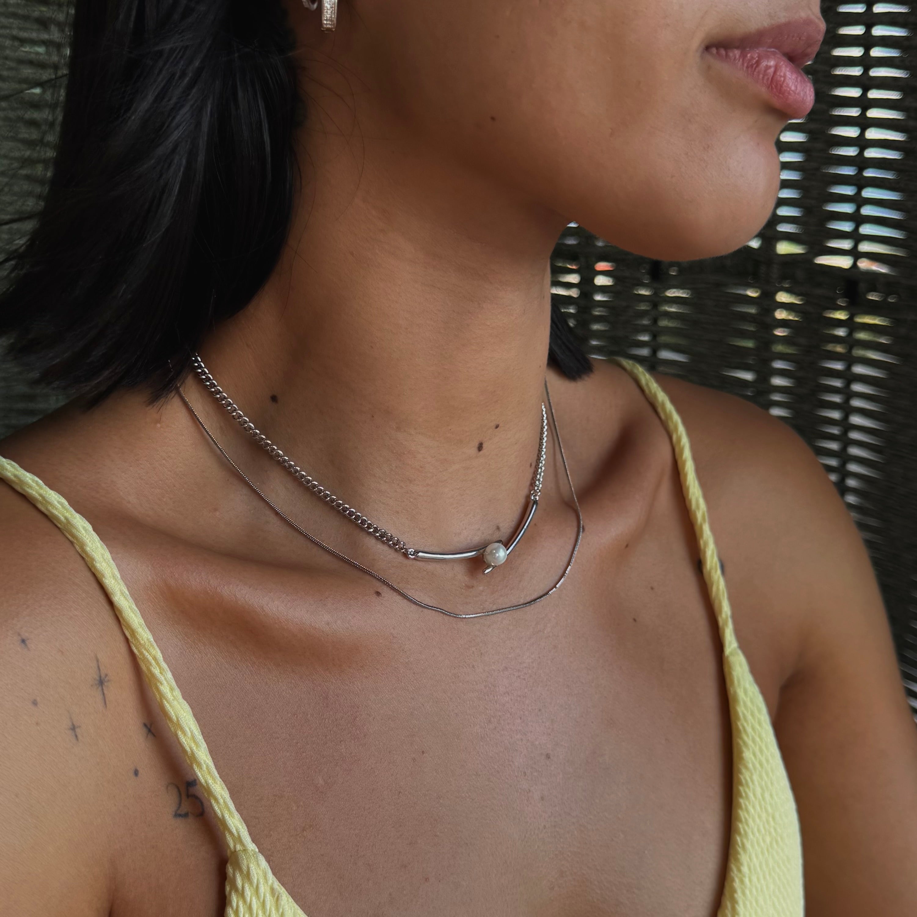Collar plateado con barra curva y tipo perla