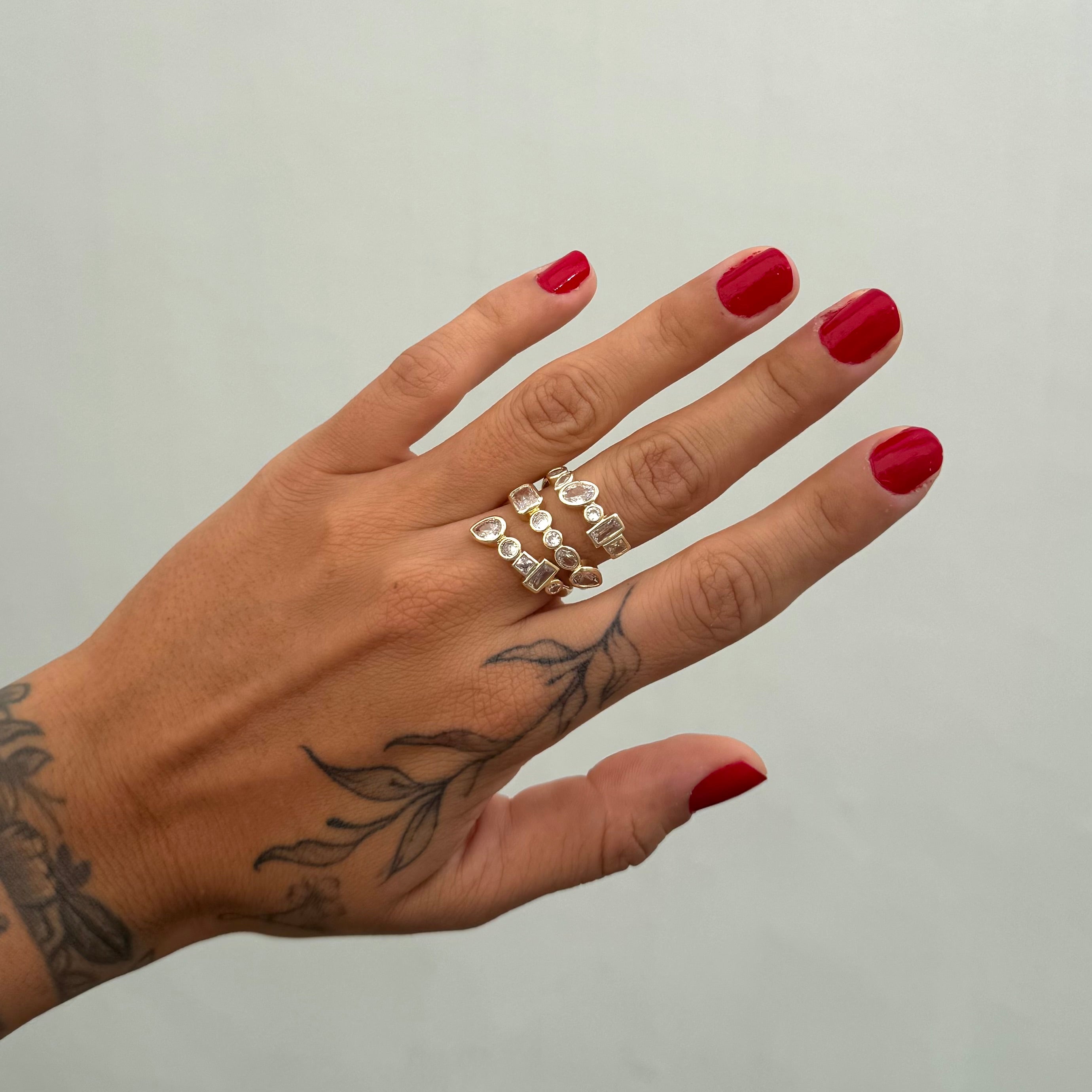 Anillo ajustable en espiral triple con piedras blancas asimétricas.