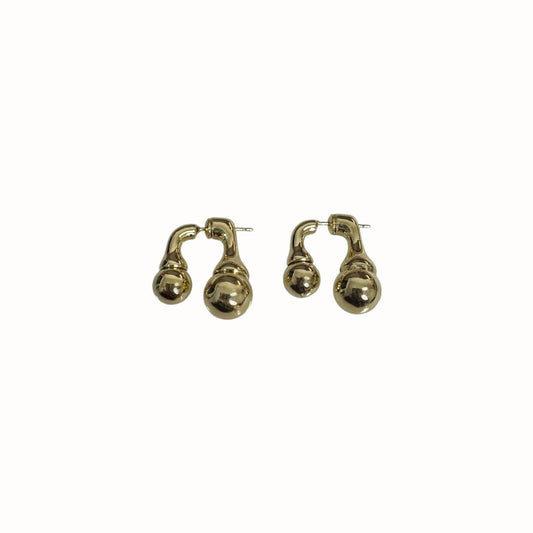 Aretes esculturales con forma orgánica.