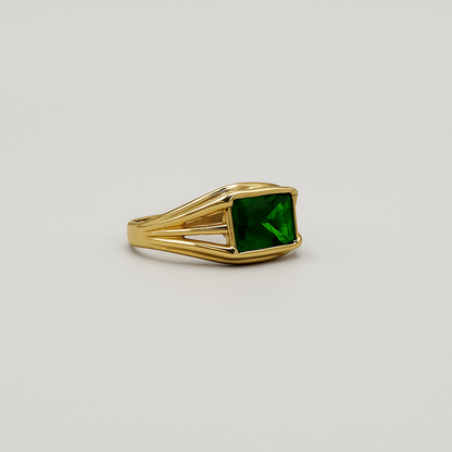 Anillo con diseño de barras sujetando una piedra verde.
